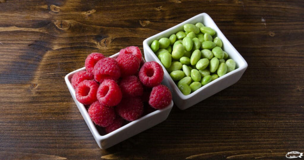 A serving of raspberries paired with a serving of edamame