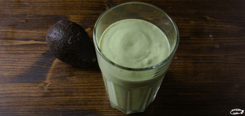 A green smoothie containing spinach, avocado and nuts.