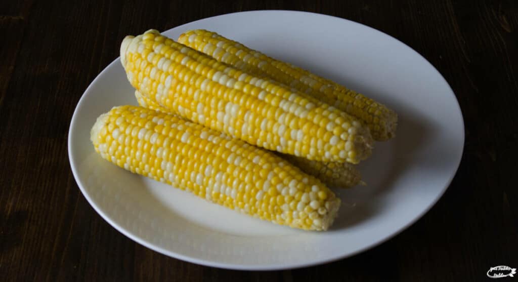 4 cobs of corn on a plate.