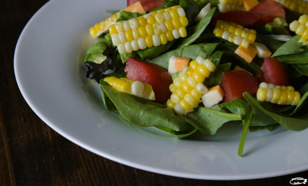 A closeup view of a salad with corn as a main ingredient.